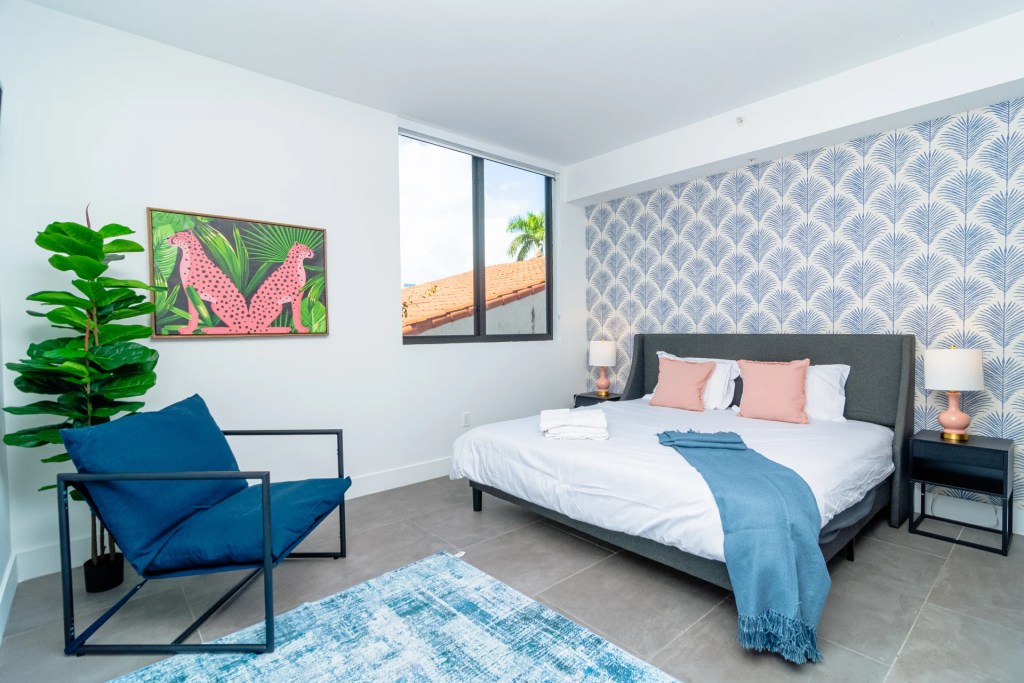 bedroom with grey bed and blue chair