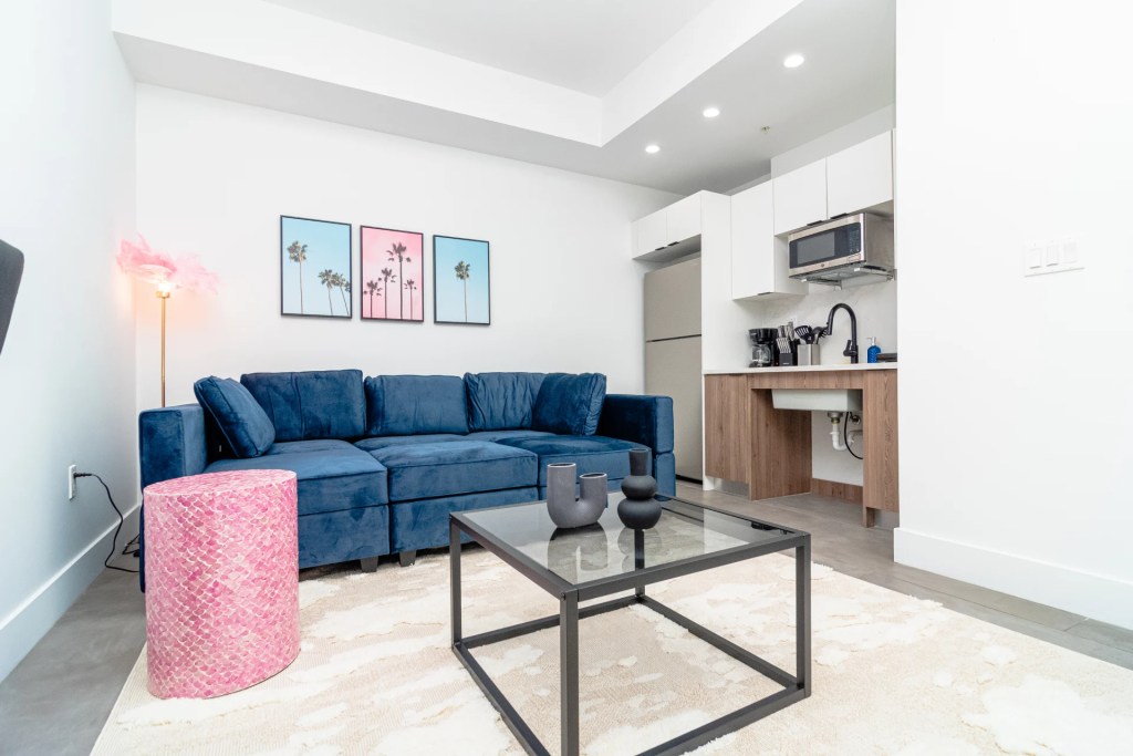 living room with blue sofa and pink decor